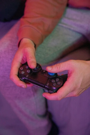 a person holding a video game controller in their hands, purple - tinted, square, shot with sony alpha, in-game