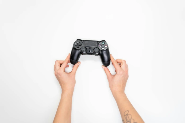 a person holding a video game controller in their hands, by Carey Morris, unsplash, minimalism, square enix, black on white background, ps 4 gameplay, sony alpha a6400