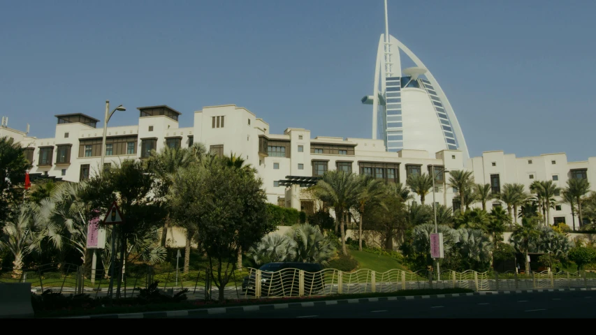 a tall building sitting on top of a lush green hillside, pexels, hurufiyya, gta : dubai, from street level, weta fx, front view