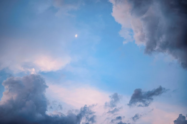 a plane flying through a cloudy blue sky, inspired by Elsa Bleda, pexels contest winner, aestheticism, moon light, pastel blues and pinks, looking upwards, humid evening