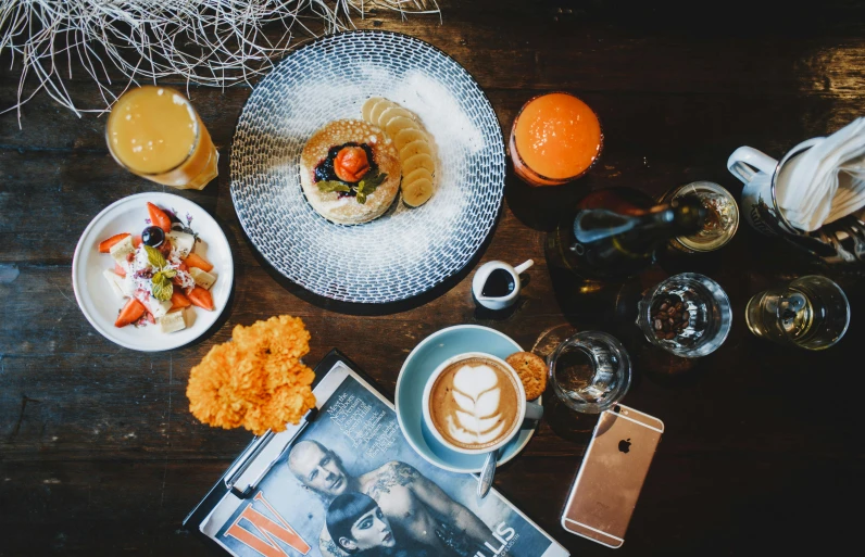 a table topped with plates of food and drinks, a still life, pexels contest winner, happening, breakfast, gray and orange colours, small hipster coffee shop, thumbnail