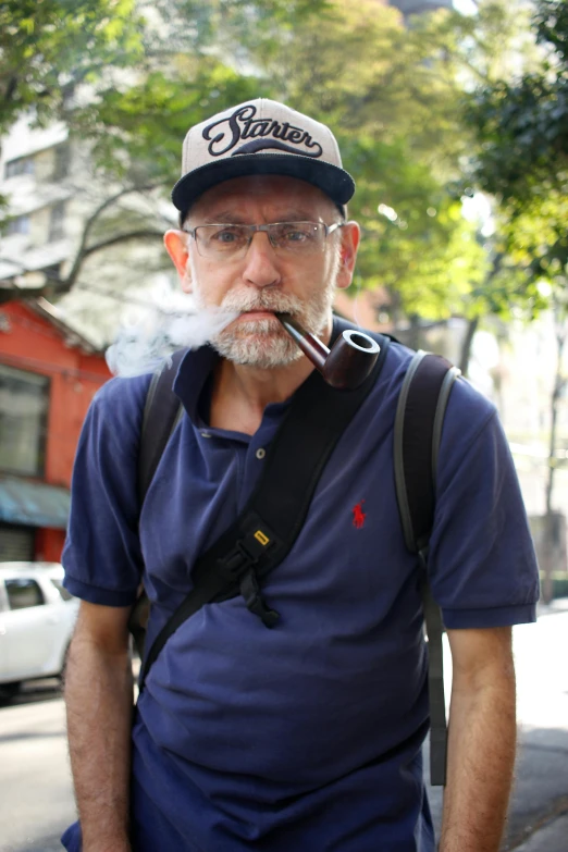 a man standing on the side of a street with a cigarette in his mouth, reddit, white hair and white beard, in sao paulo, profile image, holding a small vape