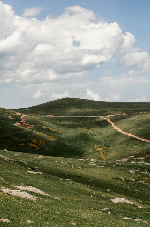 a man riding a horse on top of a lush green hillside, les nabis, natural stone road, color photo, an expansive grassy plain, nika maisuradze