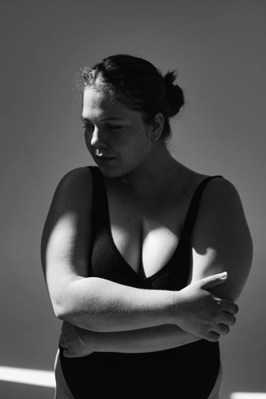 a black and white photo of a woman in a bathing suit, inspired by Max Dupain, unsplash, an obese, pensive, backlight body, wearing bra