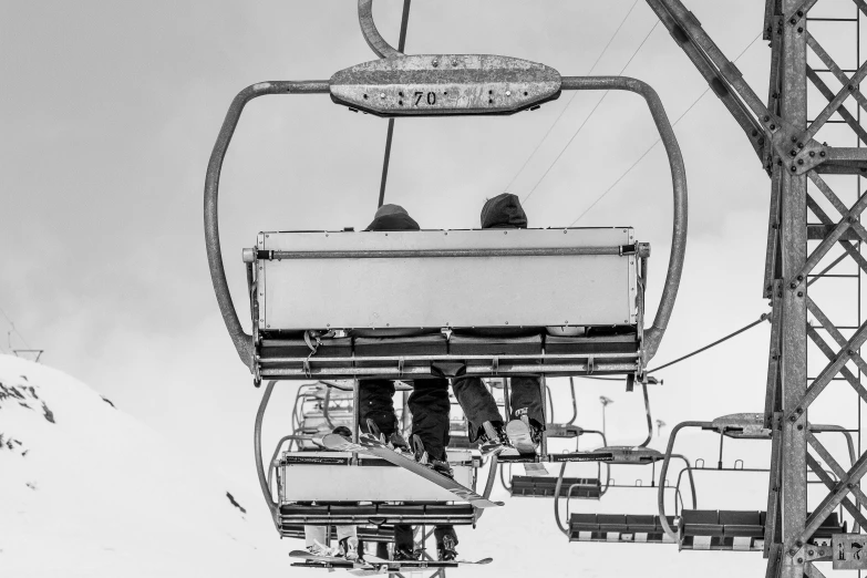 a black and white photo of people on a ski lift, a black and white photo, pexels contest winner, process art, repairing the other one, fully symmetrical, prize winning color photo, vertical