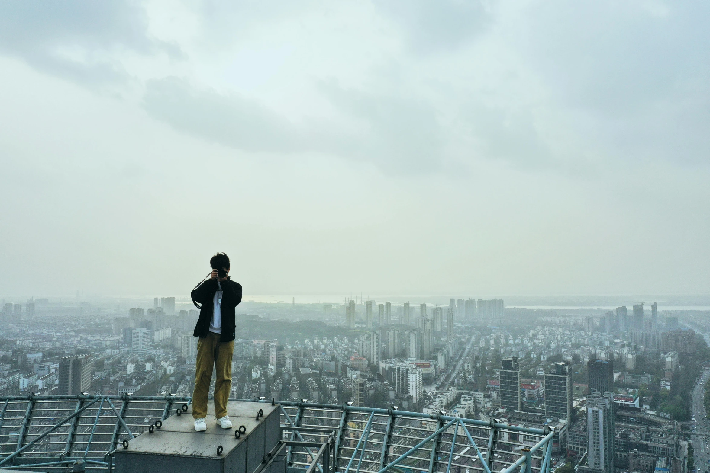 a man standing on top of a tall building, an album cover, inspired by Zhang Kechun, unsplash contest winner, happening, looking over city, jinyoung shin, movie still 8 k, male ulzzang