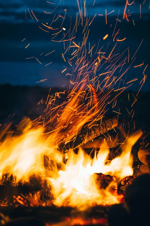 a group of people sitting around a campfire, pexels contest winner, visual art, fire place roaring, close up shot, sparkels, profile picture