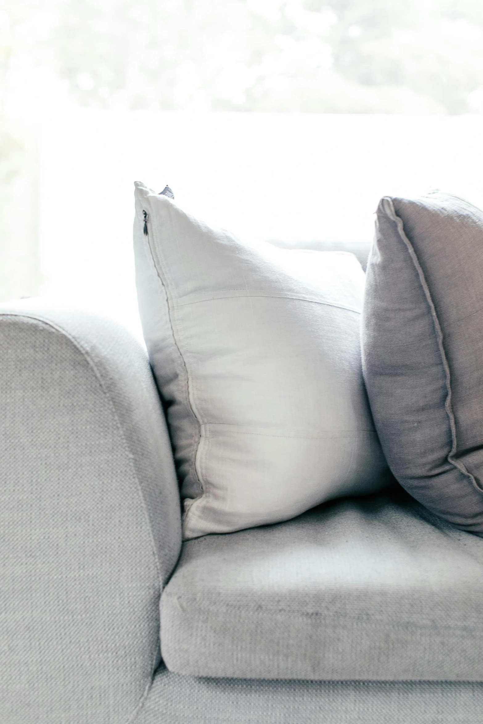 a close up of a couch with pillows on it, inspired by Lewis Henry Meakin, unsplash contest winner, beautiful natural soft rim light, grey and silver, from the side, gaming