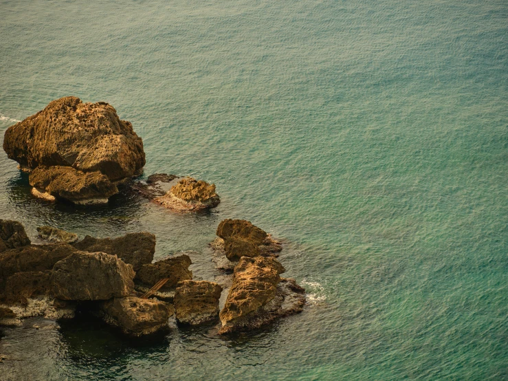 a couple of rocks sitting on top of a body of water, inspired by Elsa Bleda, pexels contest winner, renaissance, costa blanca, reefs, high quality image, fan favorite