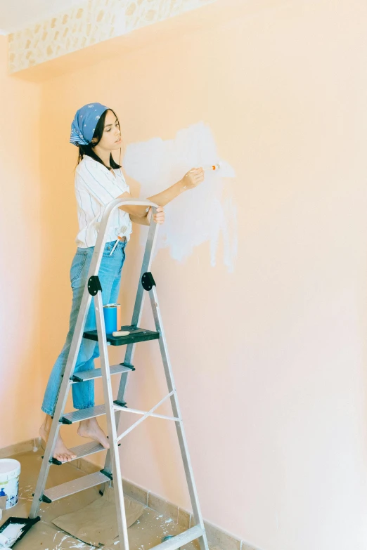 a woman standing on a ladder painting a wall, trending on pexels, arbeitsrat für kunst, pastel shades, a young asian woman, 15081959 21121991 01012000 4k, etsy