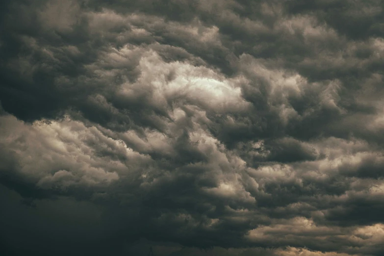 a black and white photo of a cloudy sky, by Carey Morris, pexels contest winner, baroque, turbulent storm clouds, beige and dark atmosphere, yellow clouds, instagram post