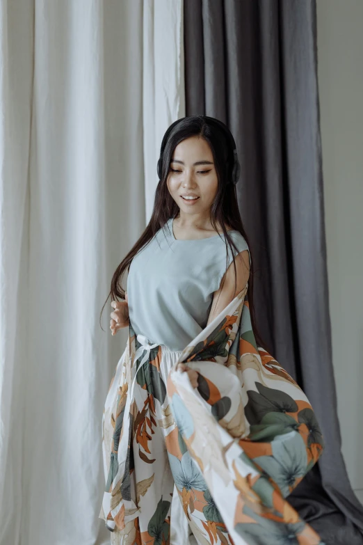 a woman standing in front of a curtain, by Basuki Abdullah, unsplash, wearing a flowing sundress, gif, young asian woman, casual