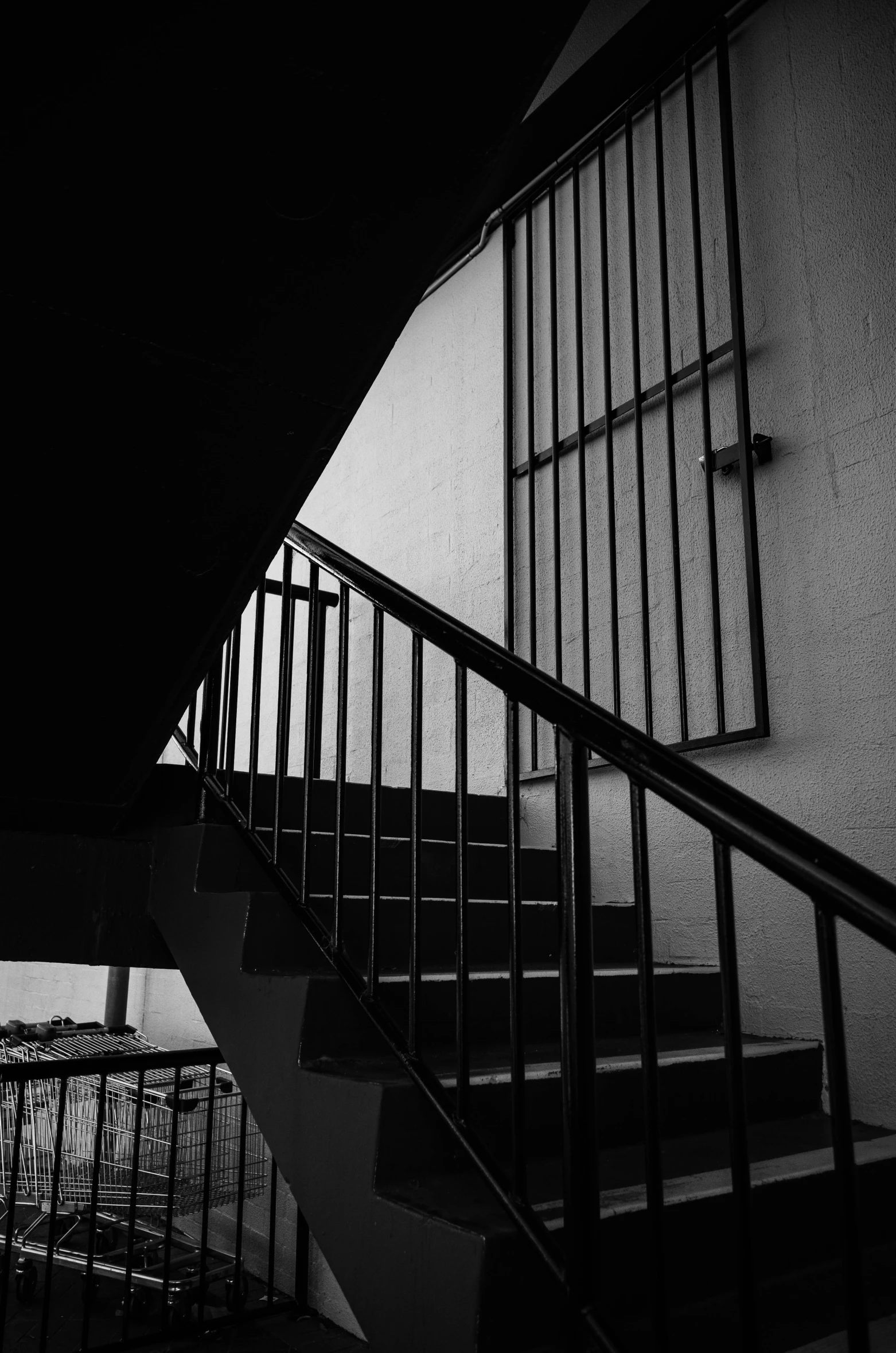 a black and white photo of a staircase, a black and white photo, inspired by Louis Stettner, unsplash, brutalism, square lines, silhouette :7, behind bars, color and contrast corrected