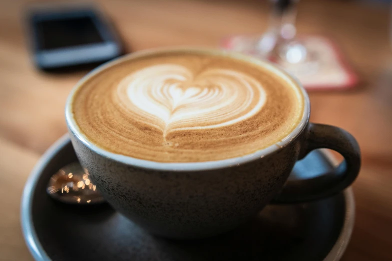 a cup of coffee sitting on top of a saucer, by Carey Morris, pexels contest winner, latte art, small heart - shaped face, thumbnail, sparkling