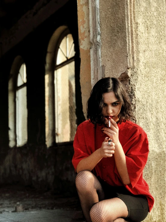 a woman sitting on the ground smoking a cigarette, inspired by Elsa Bleda, pexels contest winner, red shirt, with pistol, bella ragazza, ( ( theatrical ) )