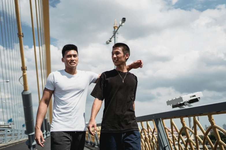 two men standing next to each other on a bridge, happening, set on singaporean aesthetic, portrait image, wearing adidas clothing, mid shot photo