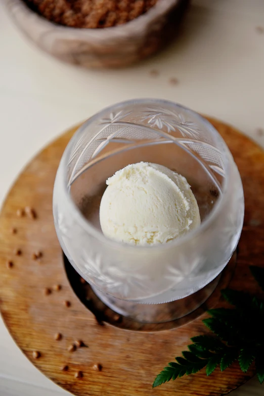 a glass of ice cream sitting on top of a wooden plate, botanicals, ignant, centered shot, sleek white