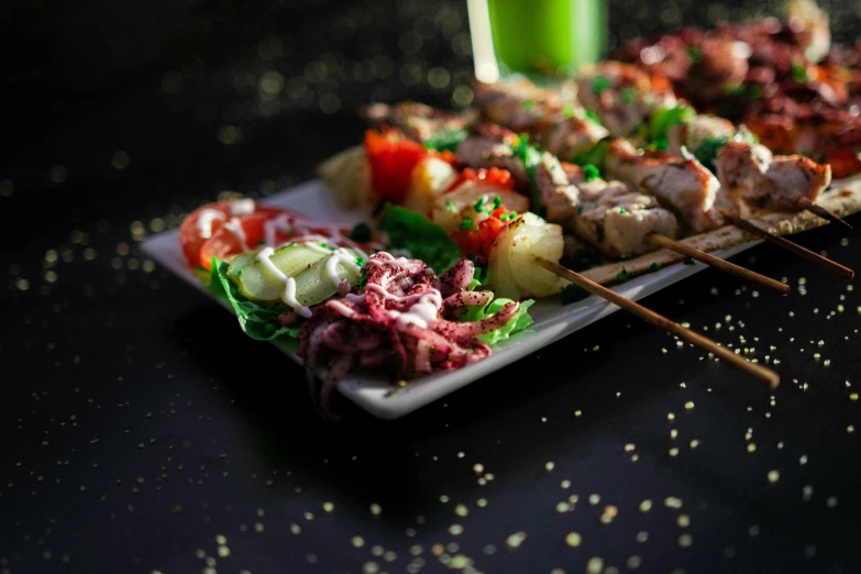 a close up of a plate of food on a table, by Niko Henrichon, pexels contest winner, fantastic realism, skewer, green, squids, best lighting