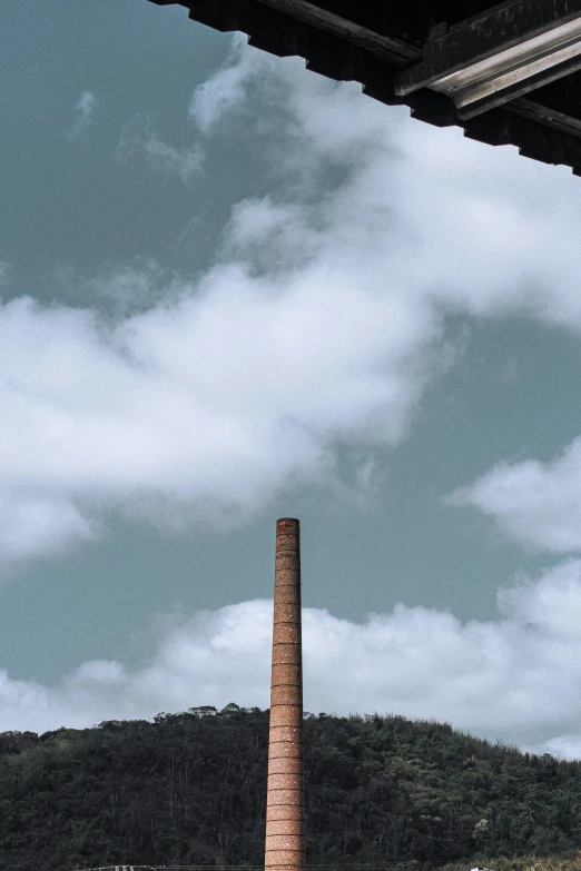 a view of a factory with a mountain in the background, an album cover, unsplash contest winner, chimney, sydney park, taken in the 2000s, terracotta