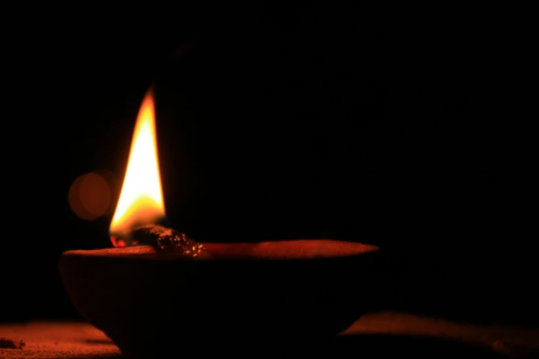 a lit candle sitting on top of a wooden table, pexels, minimalism, fire poi, emerging from a lamp, ring lit, animation