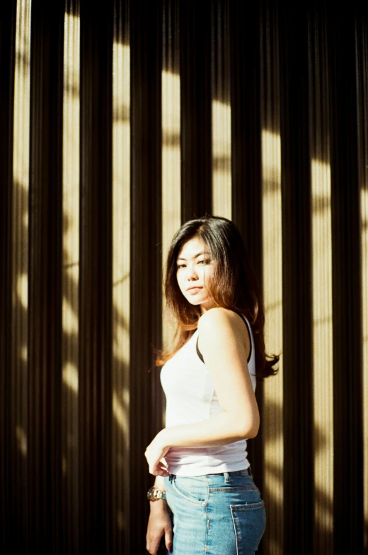 a woman standing in front of a wooden wall, inspired by Ina Wong, unsplash, medium format. soft light, hot with shining sun, asian women, soft light - n 9