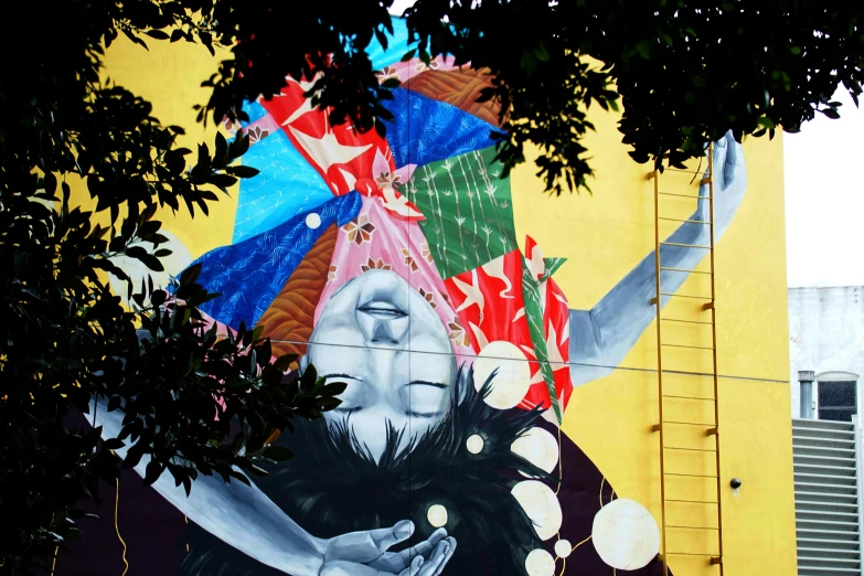 a painting of a man on the side of a building, by Noe Canjura, pexels contest winner, street art, gigantic girl head, vibrant foliage, show from below, square