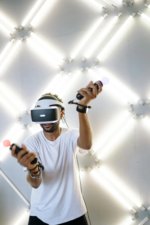 a man in a white shirt holding a video game controller, interactive art, floating vr headsets, childish gambino, london, lighting