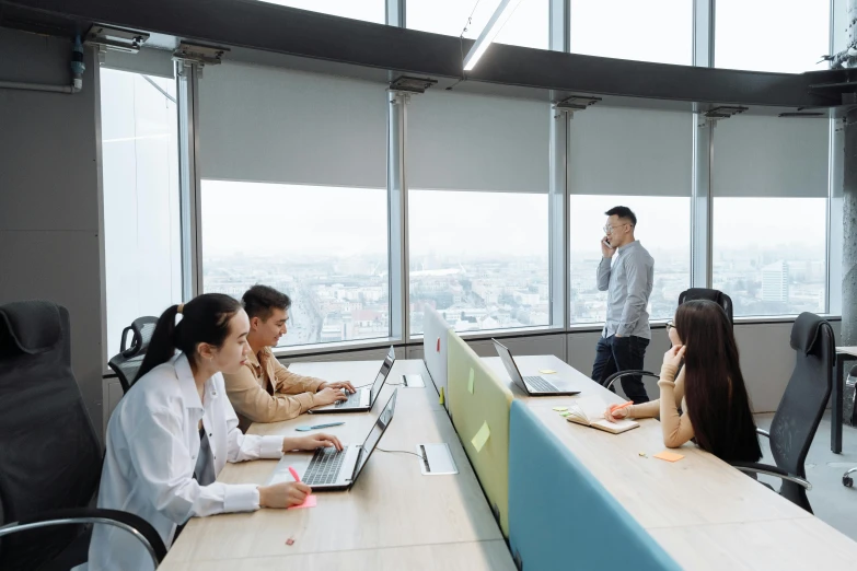 a group of people sitting at a table with laptops, by Jang Seung-eop, pexels contest winner, megatall building, avatar image