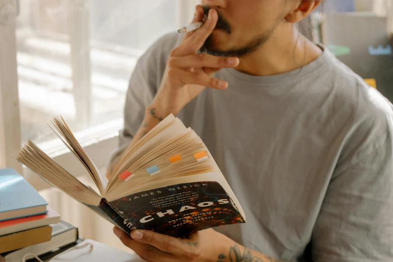 a man talking on a cell phone while reading a book, by Sam Charles, pexels contest winner, hyperrealism, cigarette in mouth, book title visible, thc, gaps and pauses