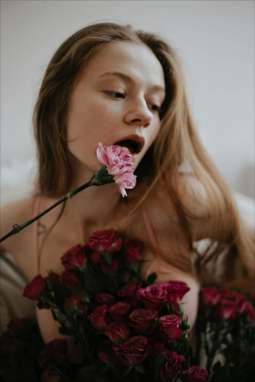a woman holding a bunch of flowers in front of her face, inspired by Elsa Bleda, pexels contest winner, romanticism, licking tongue, laying on roses, gif, redhead girl