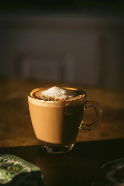 a cup of coffee sitting on top of a wooden table, sitting on a mocha-colored table, paul barson, high resolution photo, square