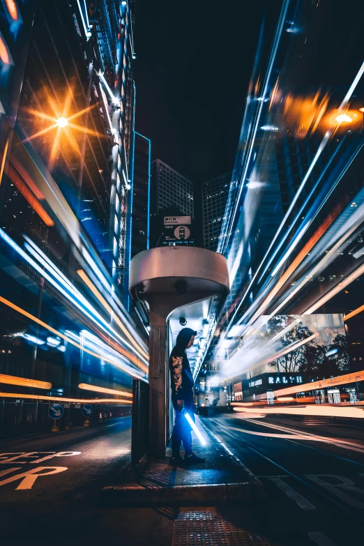 a person standing on a city street at night, by Patrick Ching, unsplash contest winner, futurism, hyperspeed, timelapse, lampposts, immersed within a network