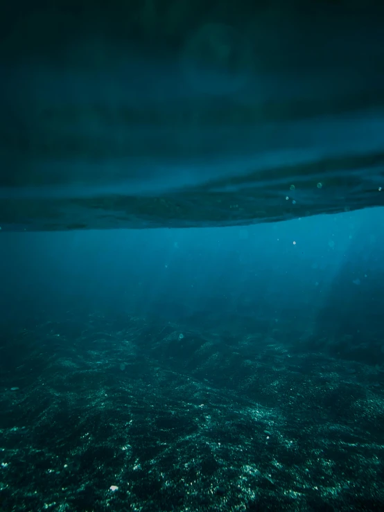 an underwater view of the ocean with sunlight shining through the water, a picture, by Elsa Bleda, 4 k cinematic photo, ominous depths, cinematic shot!, subsurface scandering