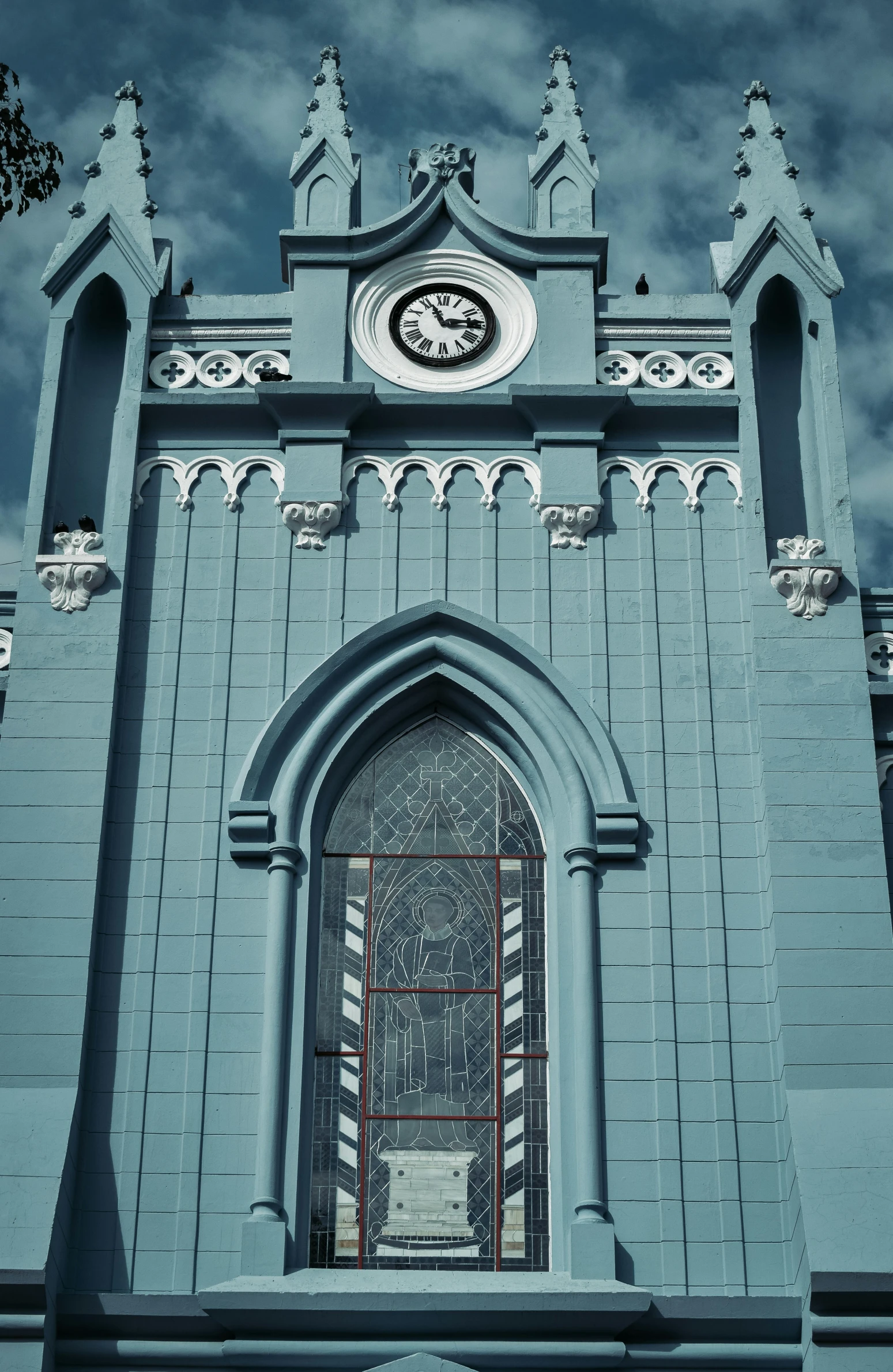 a church with a clock on the front of it, a colorized photo, inspired by Francisco Oller, unsplash, art nouveau, blue gray, southern gothic art, neo - andean architecture, rendered in cinema4d