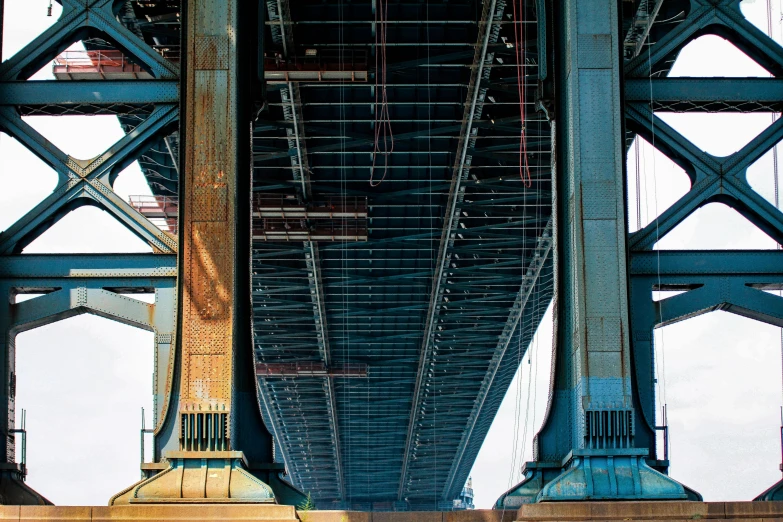 a red fire hydrant sitting under a bridge, an album cover, inspired by Thomas Struth, unsplash, hyperrealism, huge support buttresses, interior of staten island ferry, steel and metal, bridges crossing the gap