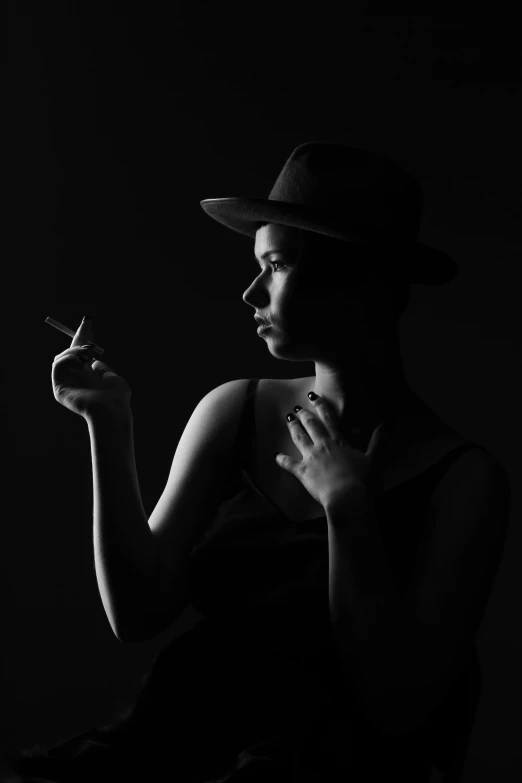 a black and white photo of a woman smoking a cigarette, inspired by George Bogart, dawn cgsociety, character with a hat, silhouette :7, androgynous person