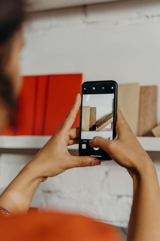 a woman taking a picture with her cell phone, a picture, pexels contest winner, modernism, shelf, sustainable materials, inspect in inventory image, centered design