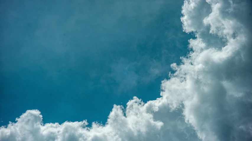 a plane flying through a cloudy blue sky, an album cover, pexels contest winner, minimalism, cumulus, looking up into the sky, hd footage, smoke in sky