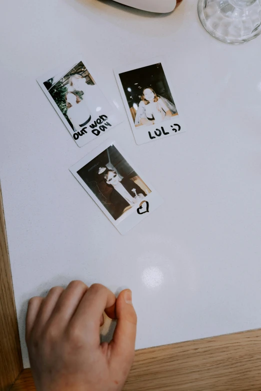 a close up of a person writing on a piece of paper, a polaroid photo, inspired by Elsa Bleda, stickers, whiteboard, magnetic, old yearbook photo