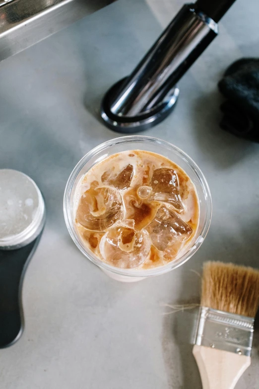 a close up of a cup of coffee on a counter, by Robbie Trevino, renaissance, iced latte, custom brush, thumbnail, silicone skin