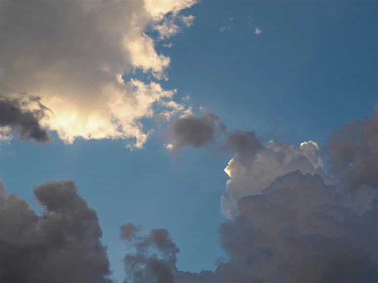 a plane flying through a cloudy blue sky, an album cover, by Carey Morris, unsplash, romanticism, cumulus clouds, late afternoon light, ignant, alessio albi