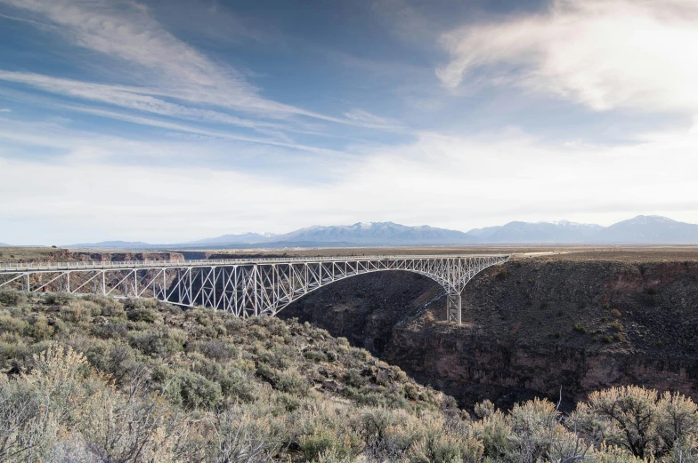 a train traveling across a bridge over a river, by Dan Frazier, unsplash contest winner, visual art, new mexico desert, 9 9 designs, high bridges, panoramic shot