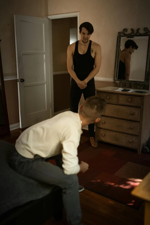 a woman standing next to a man in a living room, inspired by Nan Goldin, unsplash, dancer, beautiful boy, ( ( theatrical ) ), kneeling