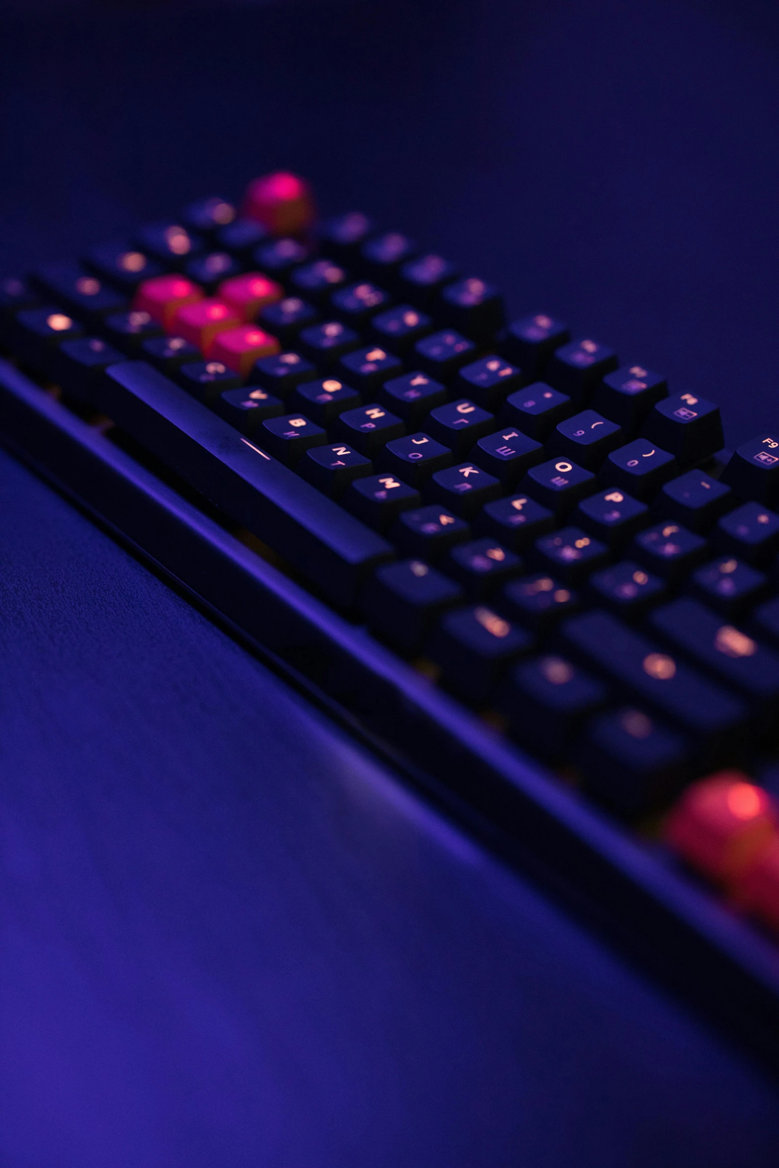 a close up of a keyboard on a table, a digital rendering, reddit, computer art, purple and red, red dot, low - angle shot, dark blue + dark orange