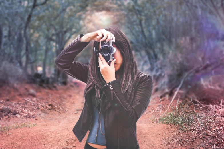 a woman taking a picture with a camera, a picture, by Lucia Peka, pexels contest winner, art photography, in front of a forest background, retro stylised, hd photography street, 🤠 using a 🖥