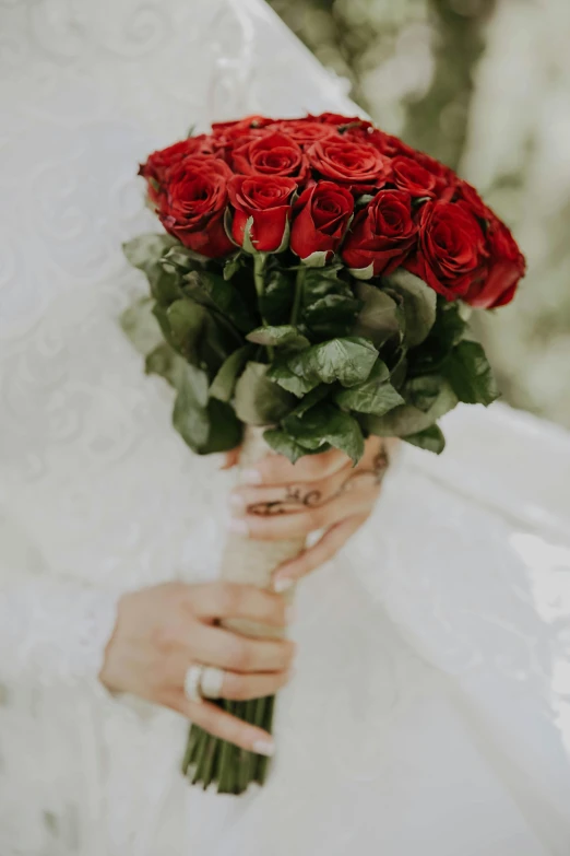 a bride holding a bouquet of red roses, a colorized photo, inspired by Modest Urgell, unsplash, 👅 👅, low detail, true love, subtle detailing