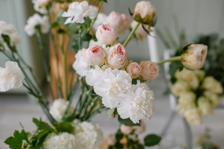 a table topped with vases filled with white and pink flowers, by Elsie Few, unsplash, close up shot from the side, rose-brambles, low details, detail shot