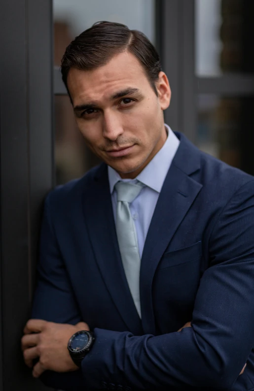 a man in a suit leaning against a wall, a portrait, trending on pexels, seductive smirk, avatar image, david marquez, anton fadeev 8 k