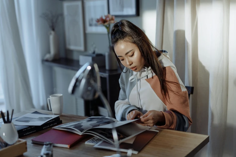 a woman sitting at a table reading a magazine, pexels contest winner, hyperrealism, young asian girl, working in an office, at home, 15081959 21121991 01012000 4k