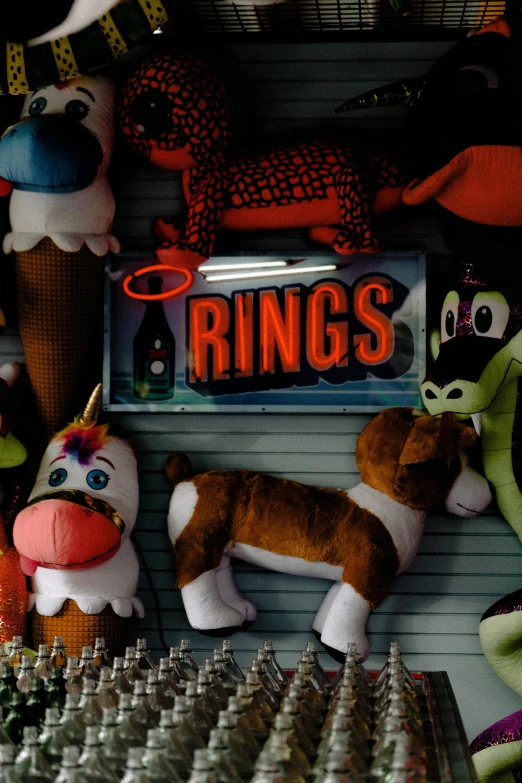 a bunch of stuffed animals sitting on top of a shelf, a cartoon, toyism, rings, at night, reuters, fairground rides